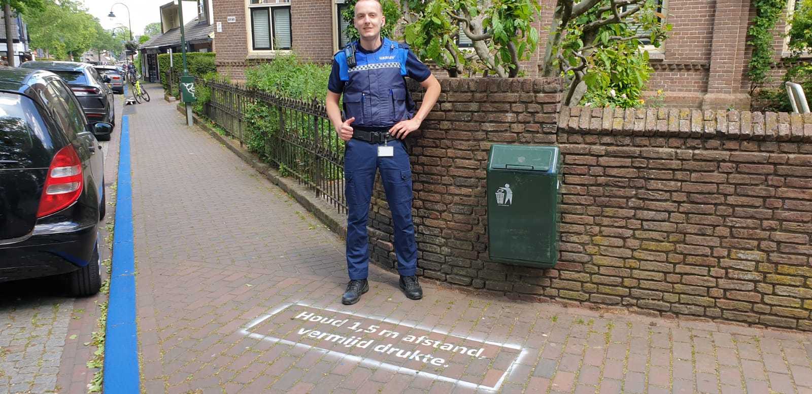 Een BOA staat in Laren met zich voor zich op de grond de tekst